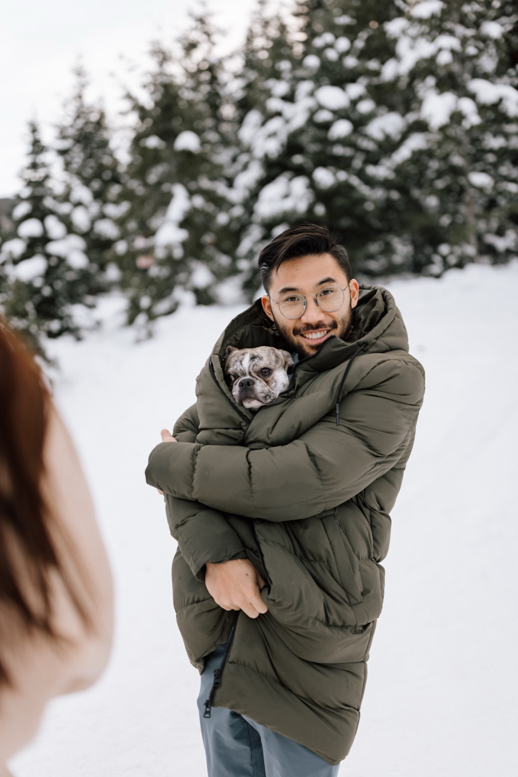 Henry Nguyen holding George outdoors in the snow.